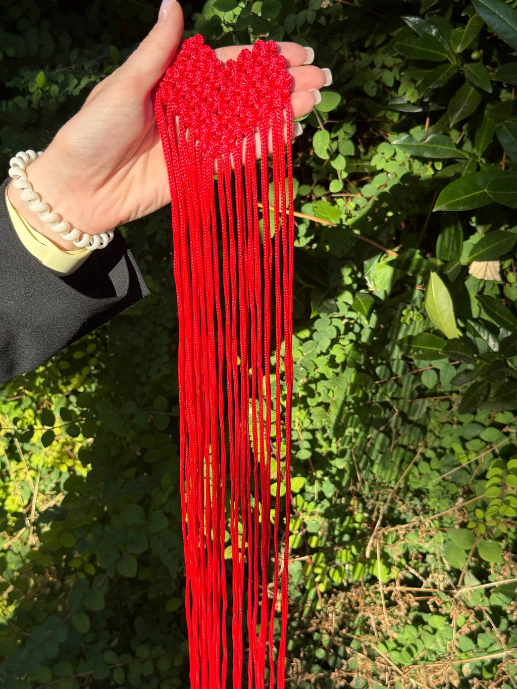 Red Fringe Brooch — full fringe held in hand
