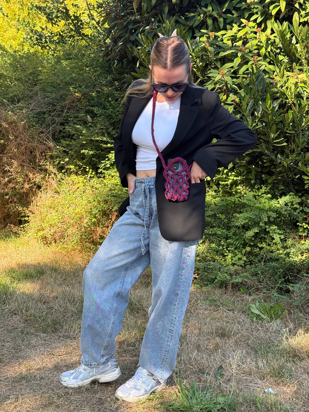 Burgundy Crochet Phone Bag — worn crossbody by model in black blazer