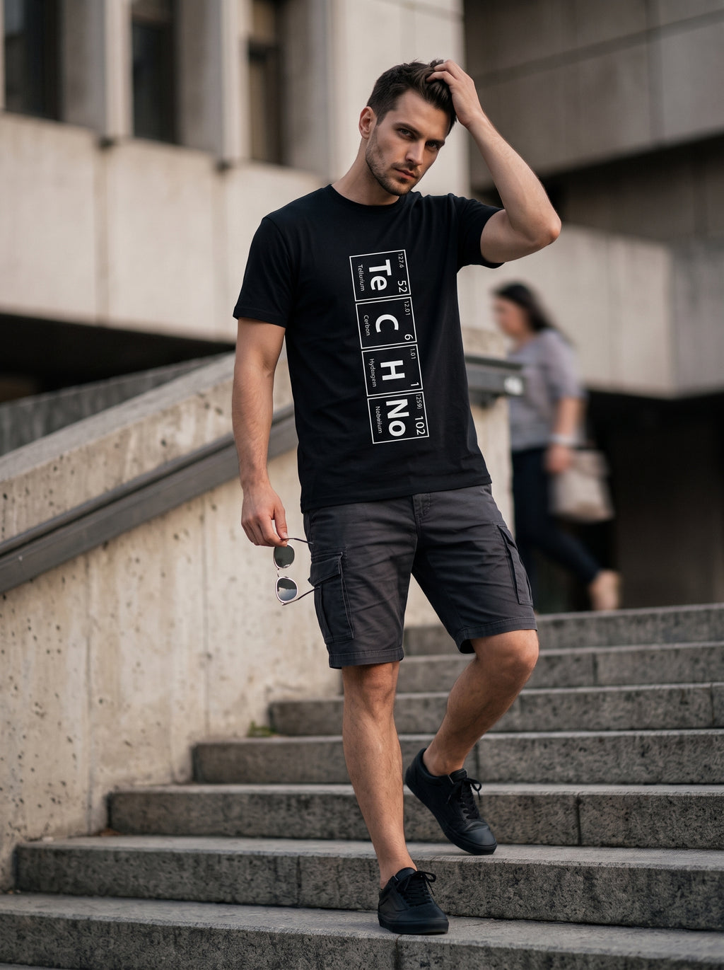 TeCHNo Elements Tee Vertical — black t-shirt with vertical periodic table TECHNO print worn by man on stairs