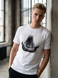 Sloth Tee — white t-shirt with realistic sloth in meditation pose worn by young man in loft