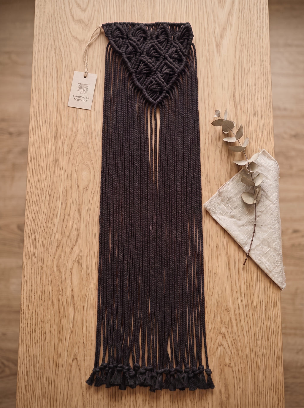 Macrame Fringe Belt in Dark Brown — flat lay on wooden surface